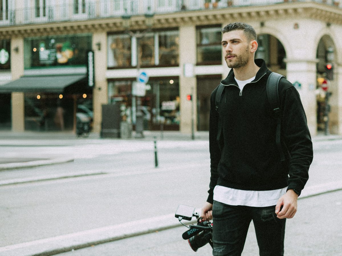 Jérémie, caméra à la main, dans une rue de Paris
